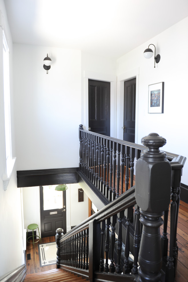 Foto de escalera recta ecléctica de tamaño medio con escalones de madera, contrahuellas de madera pintada y barandilla de madera