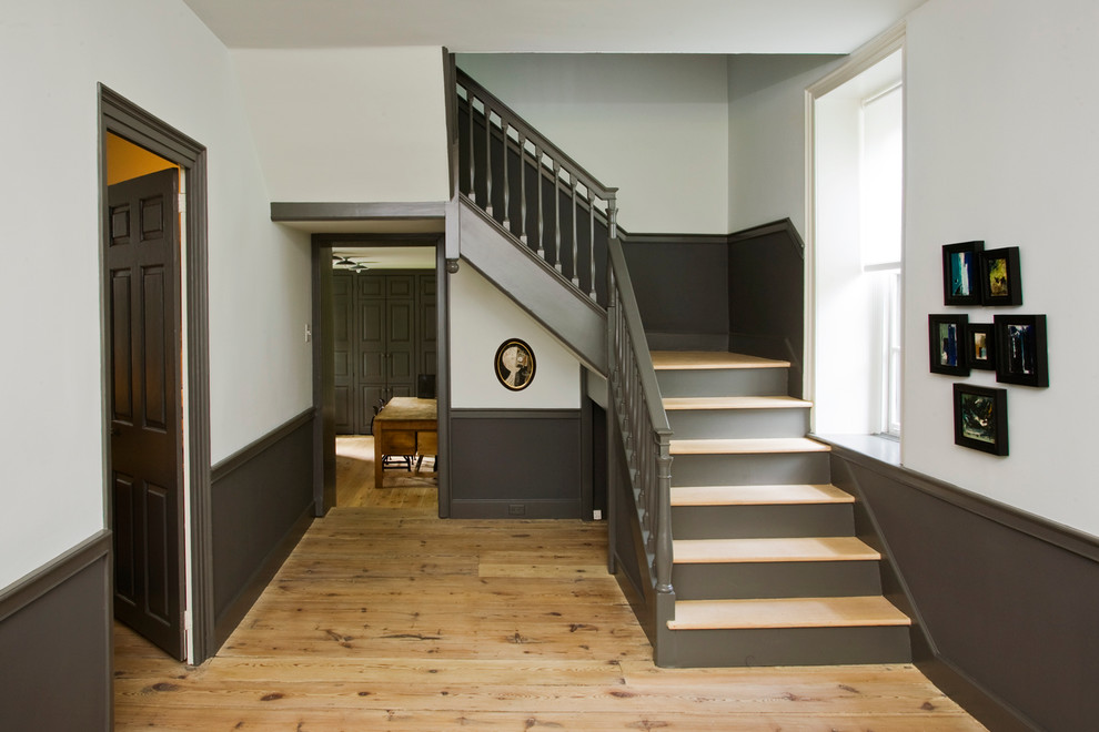 Diseño de escalera en L de estilo de casa de campo extra grande con escalones de madera y contrahuellas de madera