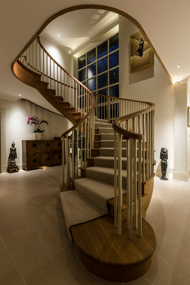 Пример оригинального дизайна: изогнутая лестница среднего размера в стиле неоклассика (современная классика) с деревянными ступенями