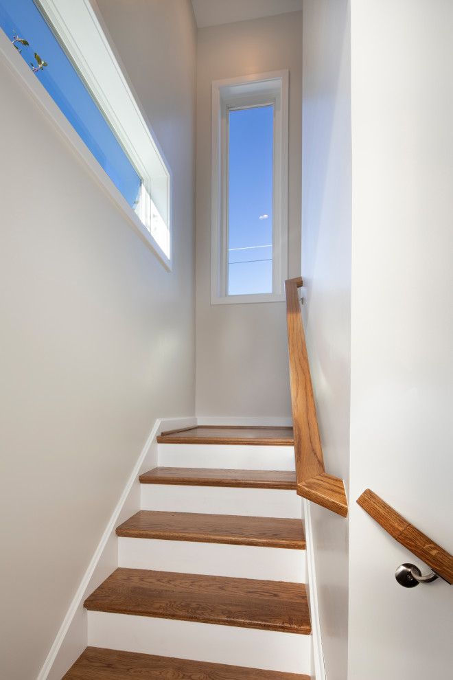Идея дизайна: угловая деревянная лестница среднего размера в стиле модернизм с деревянными ступенями и деревянными перилами