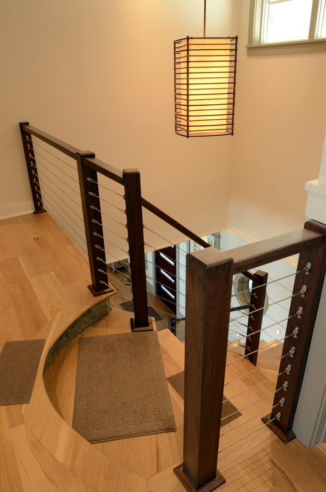 Cette photo montre un grand escalier peint tendance en L avec des marches en bois.