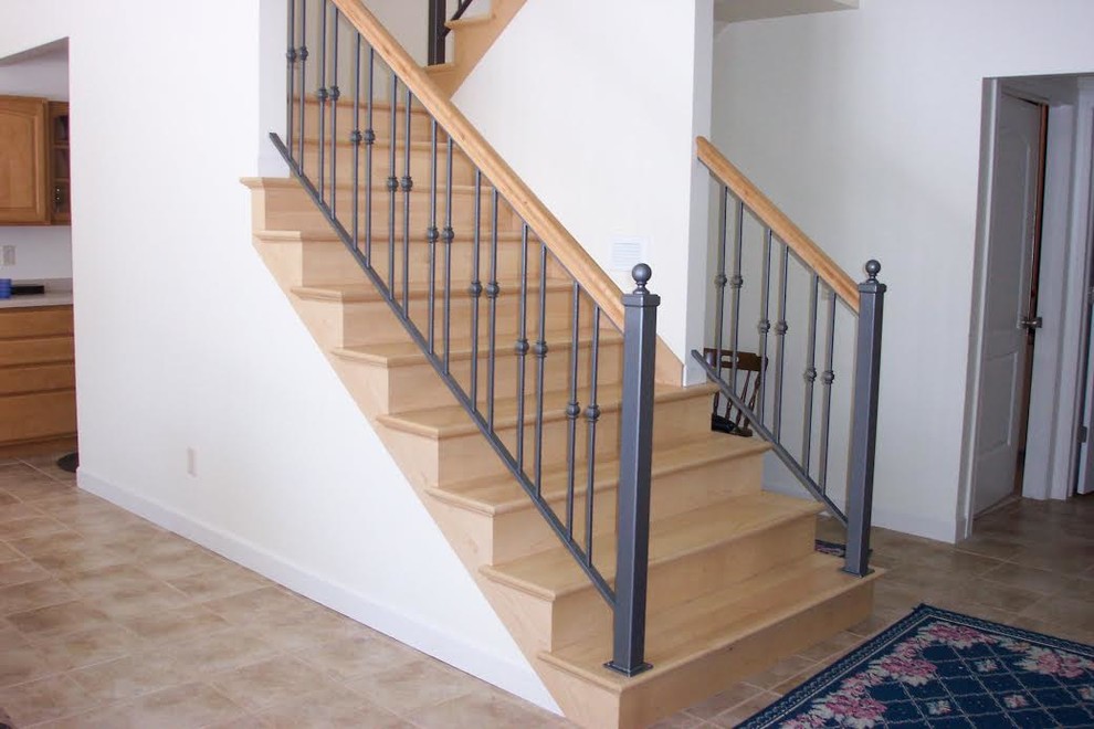 Diseño de escalera en U tradicional de tamaño medio con escalones de madera, contrahuellas de madera y barandilla de metal
