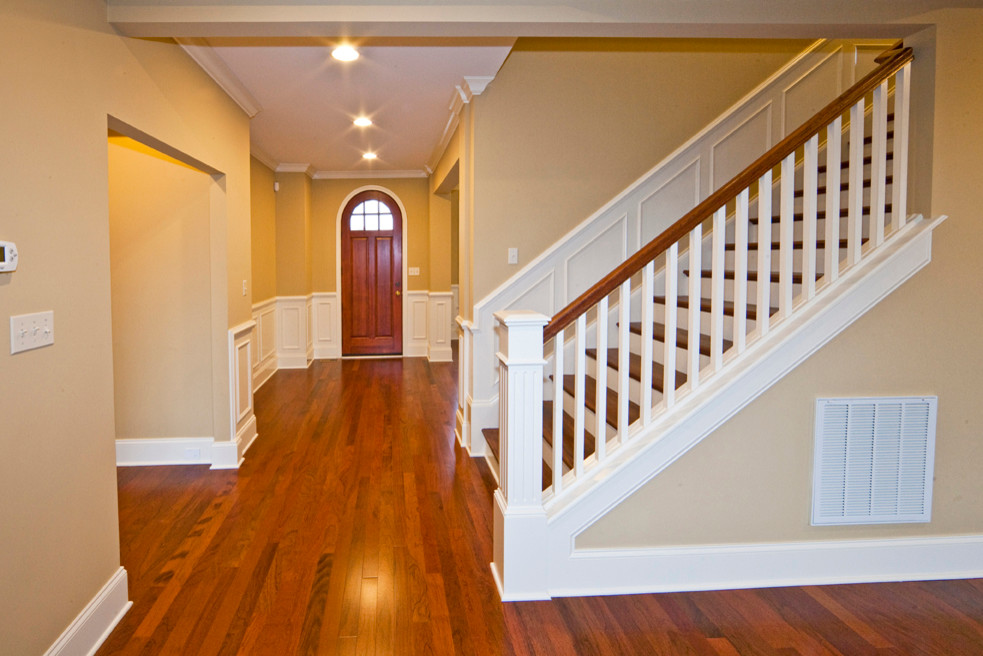 Cette photo montre un grand escalier peint droit chic avec des marches en bois.