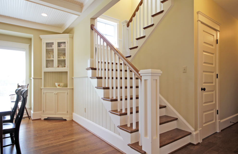 На фото: п-образная деревянная лестница среднего размера в стиле кантри с деревянными ступенями с