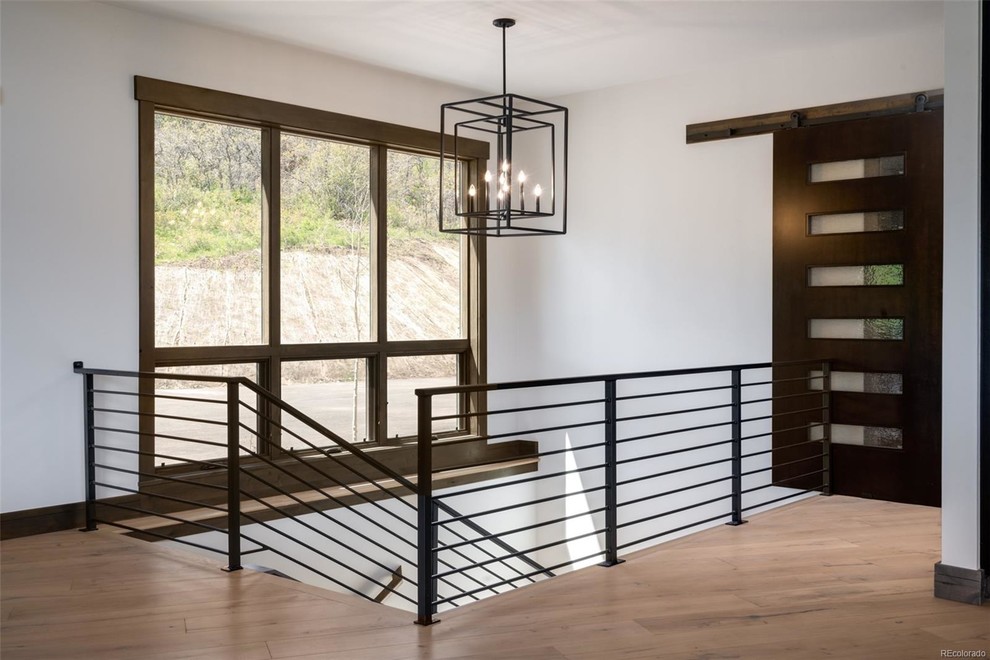 Ejemplo de escalera en U rural de tamaño medio con escalones de madera, contrahuellas de madera y barandilla de metal