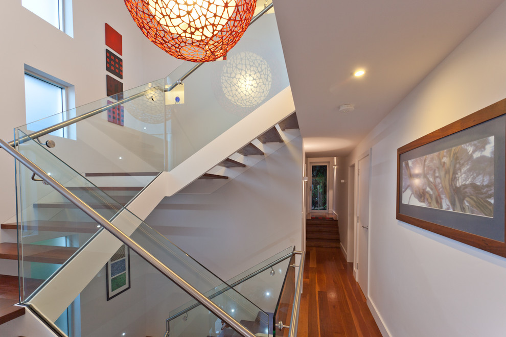 Свежая идея для дизайна: лестница на больцах, среднего размера в современном стиле с деревянными ступенями и стеклянными перилами - отличное фото интерьера