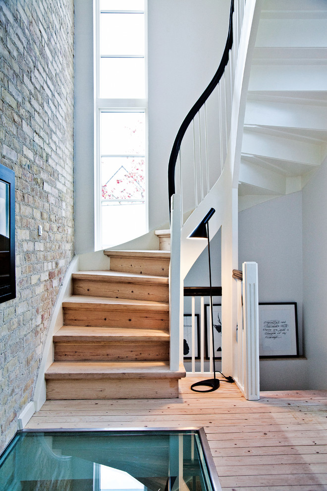 Пример оригинального дизайна: изогнутая деревянная лестница среднего размера в скандинавском стиле с деревянными ступенями