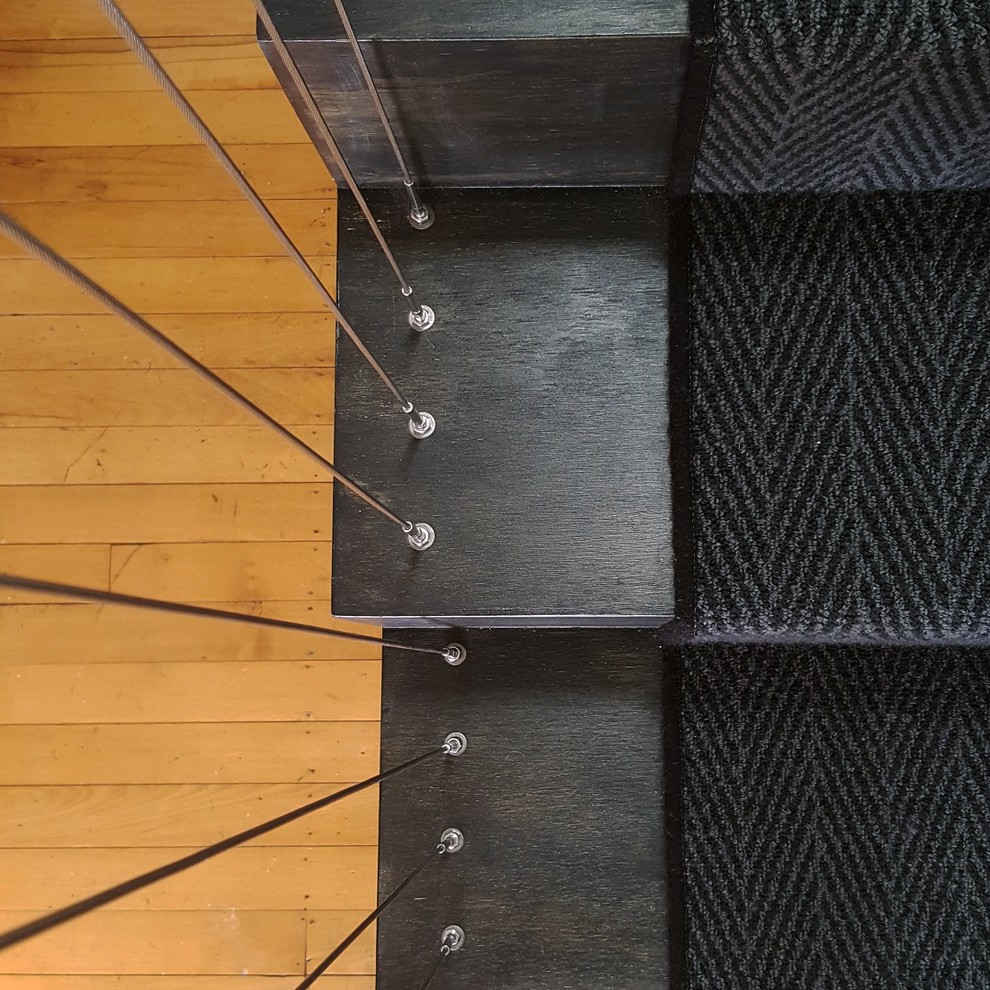 Immagine di una piccola scala sospesa industriale con pedata in legno verniciato, alzata in legno verniciato e parapetto in metallo