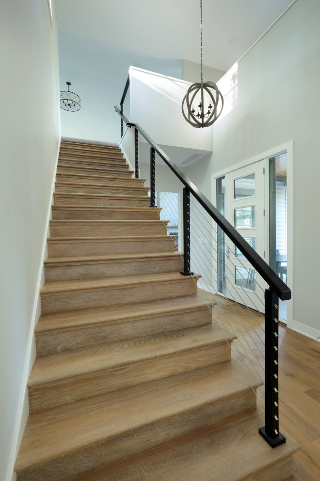Diseño de escalera recta campestre de tamaño medio con escalones de madera, contrahuellas de madera y barandilla de cable