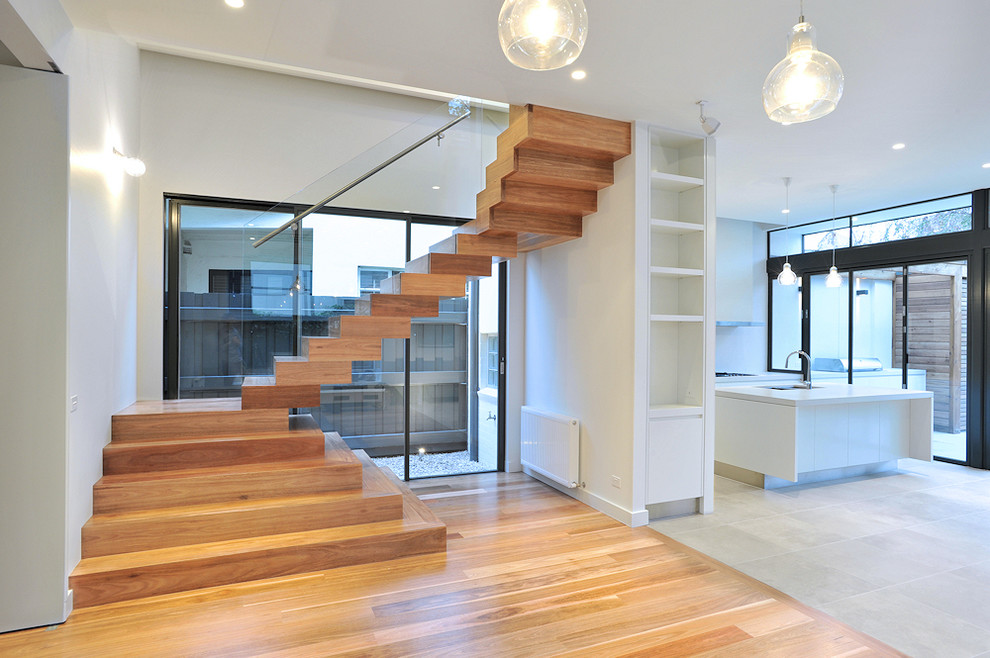 На фото: деревянная лестница на больцах, среднего размера в современном стиле с деревянными ступенями