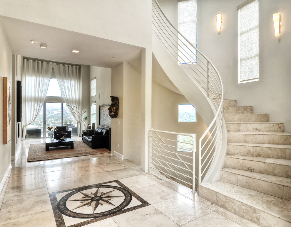 Источник вдохновения для домашнего уюта: изогнутая лестница среднего размера в стиле модернизм с ступенями из известняка, подступенками из известняка и металлическими перилами