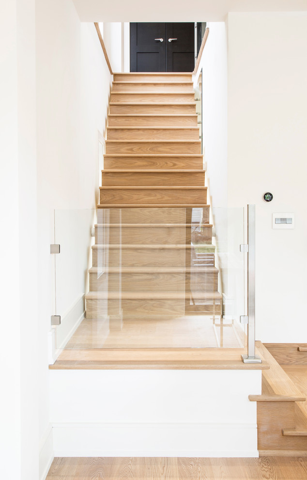 Пример оригинального дизайна: угловая деревянная лестница среднего размера в стиле модернизм с деревянными ступенями и стеклянными перилами