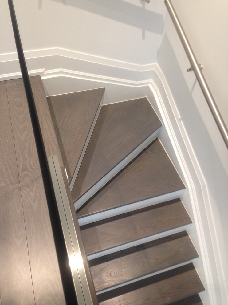 Ejemplo de escalera en L minimalista de tamaño medio con escalones de madera y contrahuellas de vidrio