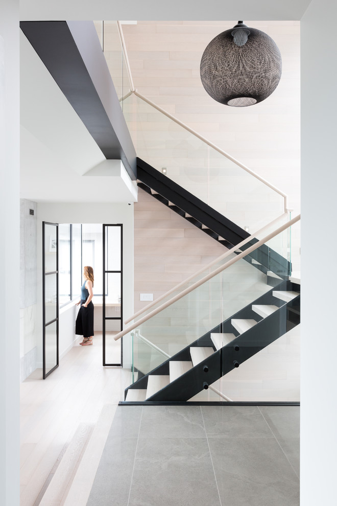 На фото: лестница на больцах, среднего размера в современном стиле с деревянными ступенями и стеклянными перилами без подступенок