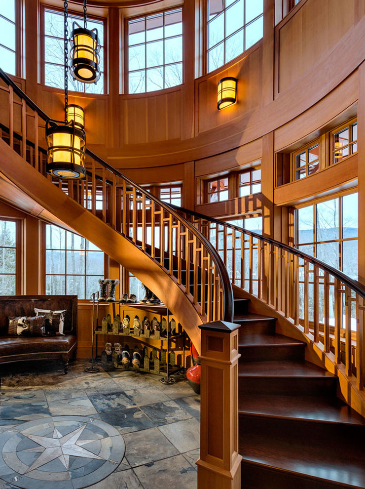 Imagen de escalera curva rústica grande con escalones de madera y contrahuellas de madera