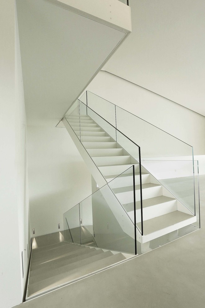 Foto de escalera recta actual con escalones de metal, contrahuellas de metal y barandilla de vidrio