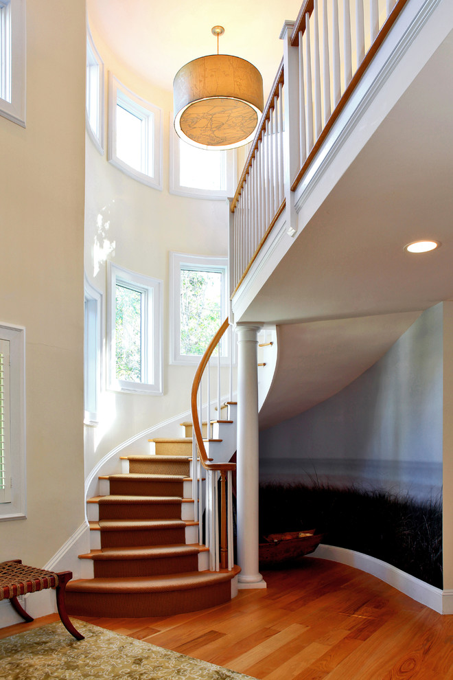 Foto de escalera curva actual con escalones de madera