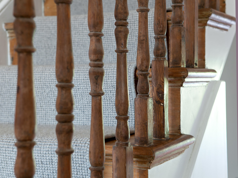 На фото: п-образная лестница среднего размера в современном стиле с ступенями с ковровым покрытием и деревянными перилами с
