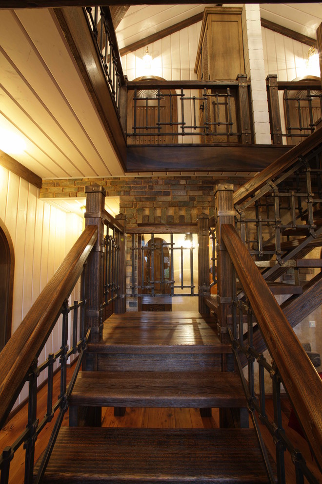 На фото: п-образная металлическая лестница среднего размера в стиле рустика с деревянными ступенями с