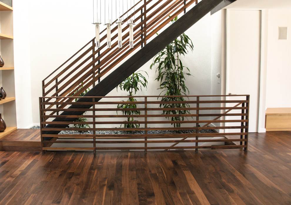 На фото: прямая лестница среднего размера в стиле модернизм с деревянными ступенями и деревянными перилами без подступенок с