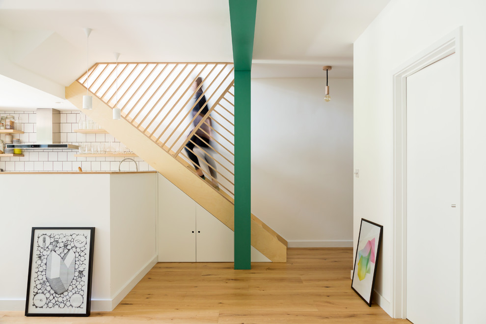 Свежая идея для дизайна: прямая лестница среднего размера в скандинавском стиле с деревянными перилами и кладовкой или шкафом под ней - отличное фото интерьера