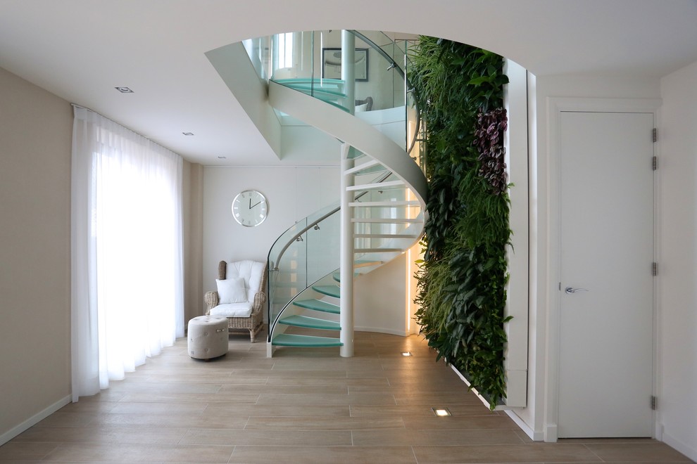 Exemple d'un escalier hélicoïdal moderne de taille moyenne avec des marches en verre et des contremarches en métal.