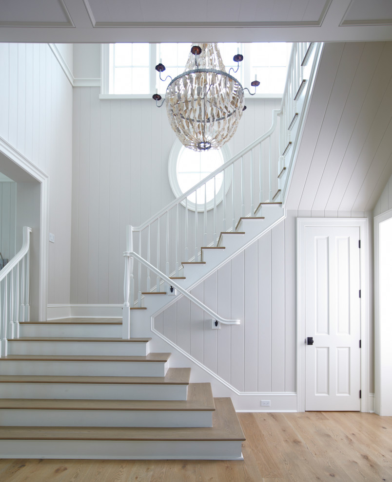 Пример оригинального дизайна: лестница в морском стиле с деревянными ступенями и крашенными деревянными подступенками