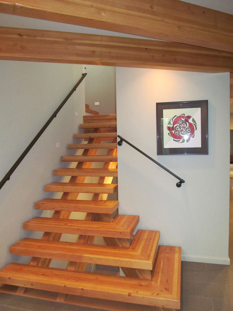 Imagen de escalera en L contemporánea grande sin contrahuella con escalones de madera y barandilla de metal