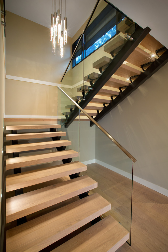 This is an example of a contemporary wood u-shaped staircase in Vancouver with open risers.