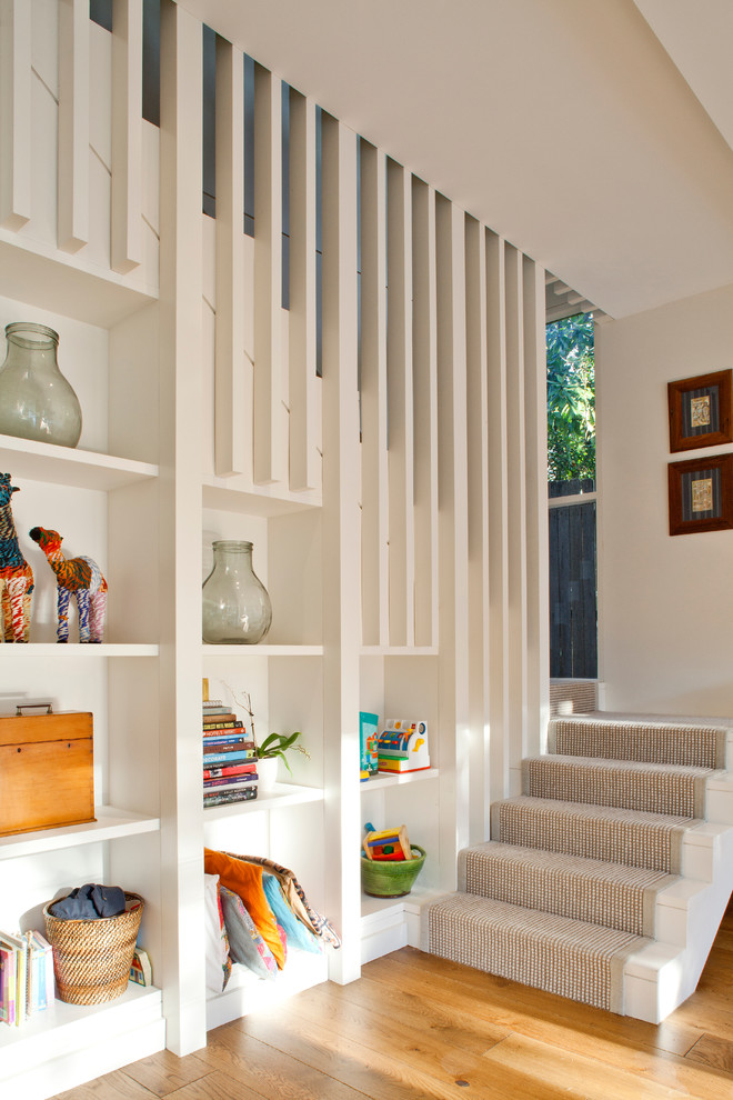 На фото: п-образная лестница в современном стиле с крашенными деревянными ступенями, крашенными деревянными подступенками и кладовкой или шкафом под ней с