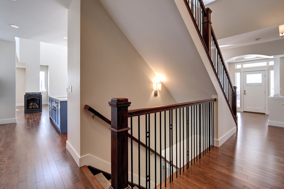 Cette photo montre un grand escalier craftsman en L avec des marches en moquette et des contremarches en moquette.