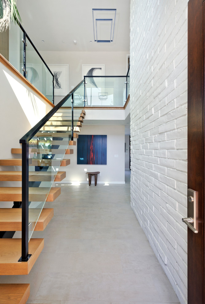 На фото: прямая лестница в стиле ретро с деревянными ступенями и стеклянными перилами без подступенок с