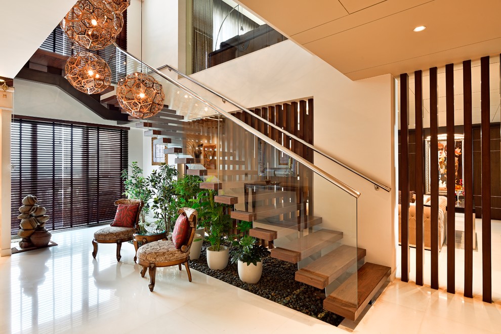 Moderne Holztreppe in L-Form mit Glas-Setzstufen und Stahlgeländer in Delhi