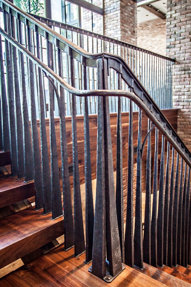 Cette image montre un grand escalier sans contremarche rustique en U avec des marches en bois.