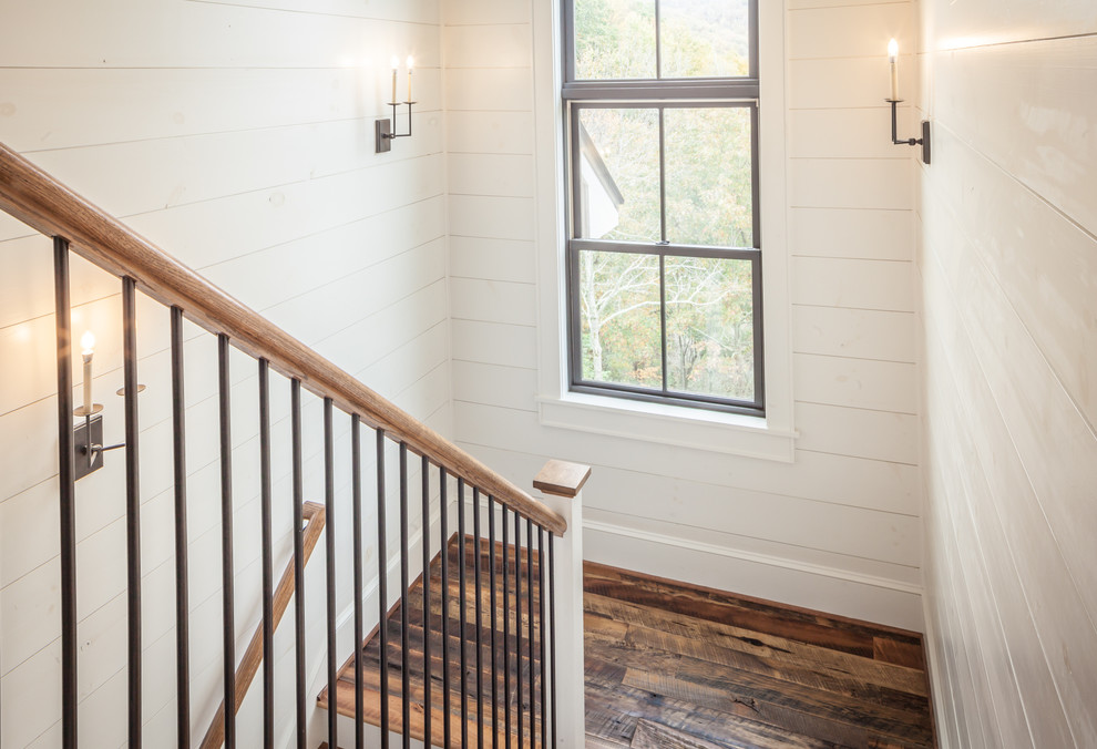 Inspiration for a large farmhouse wooden u-shaped mixed material railing staircase remodel in Other