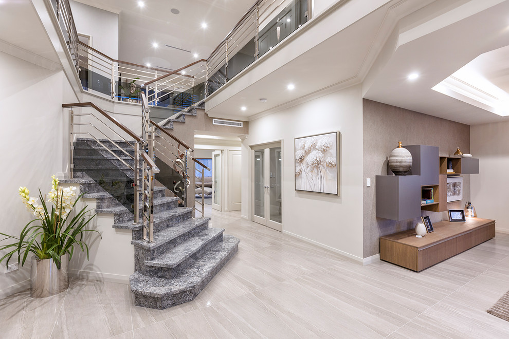 Cette image montre un grand escalier design en L et marbre avec des contremarches en marbre et un garde-corps en matériaux mixtes.