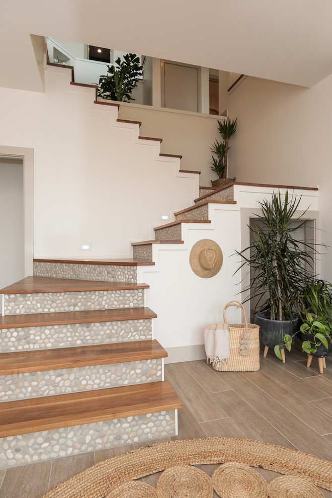Стильный дизайн: угловая лестница в морском стиле с деревянными ступенями и подступенками из плитки - последний тренд