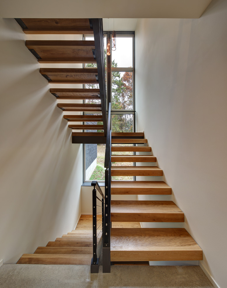 Diseño de escalera suspendida moderna sin contrahuella con escalones de madera