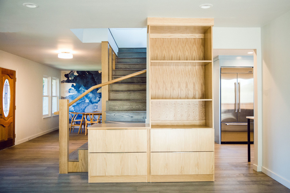 На фото: угловая деревянная лестница среднего размера с деревянными ступенями и деревянными перилами с