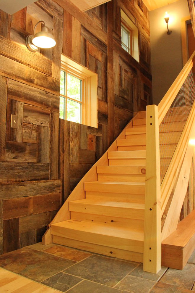 This is an example of a rustic wood straight staircase in Boston with open risers.