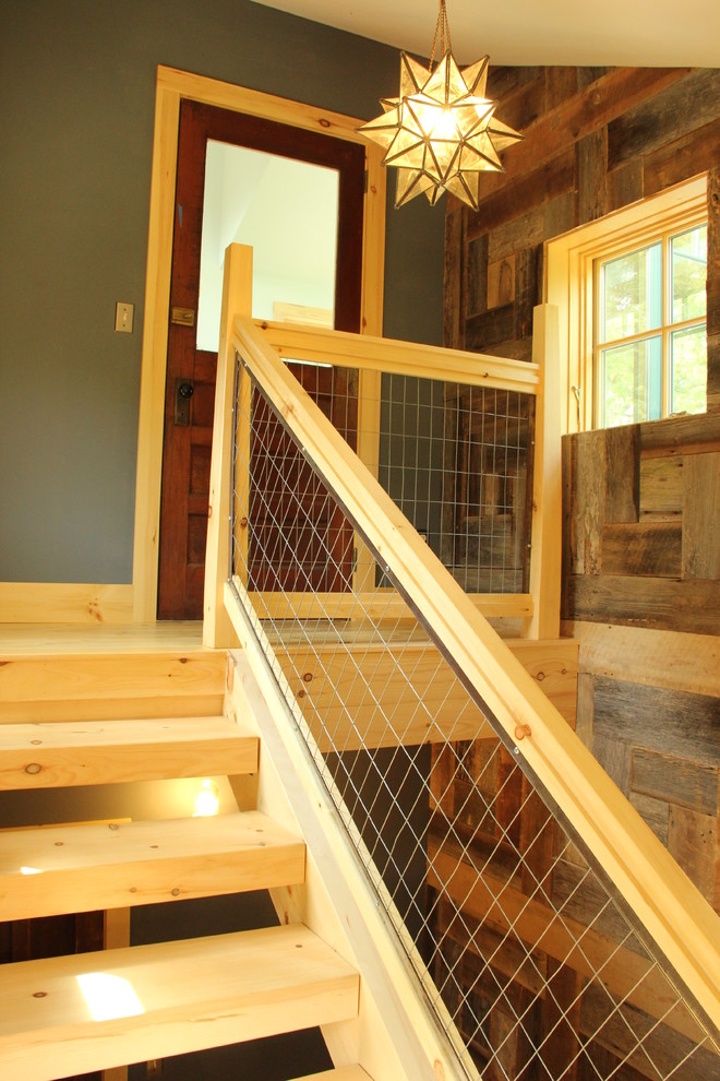 Esempio di una scala a rampa dritta stile rurale con pedata in legno e nessuna alzata