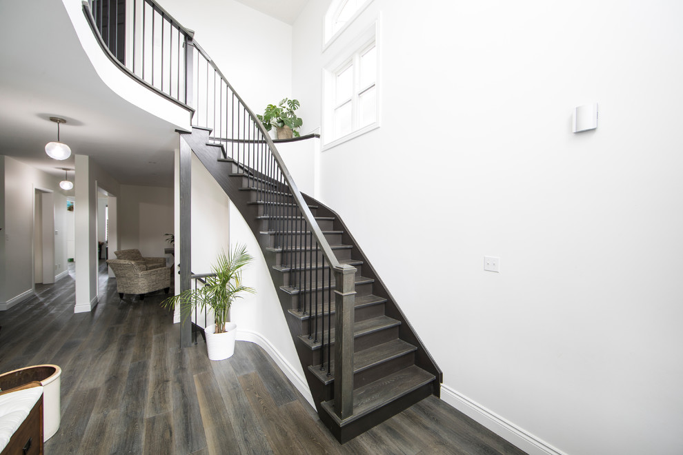 Large traditional wood curved wood railing staircase in Toronto with wood risers.