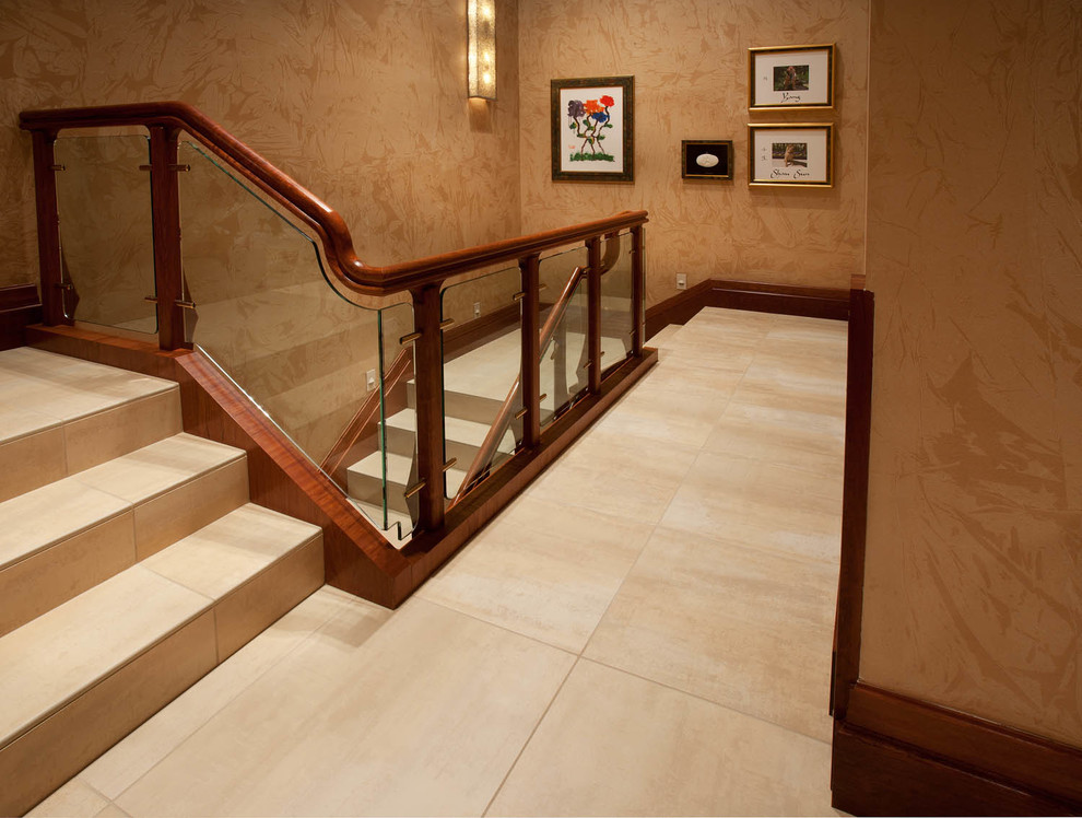 Inspiration pour un escalier design en U avec des marches en pierre calcaire, des contremarches en pierre calcaire et un garde-corps en verre.