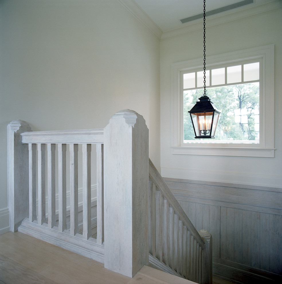 Photo of a medium sized traditional u-shaped staircase in New York with wood risers and feature lighting.