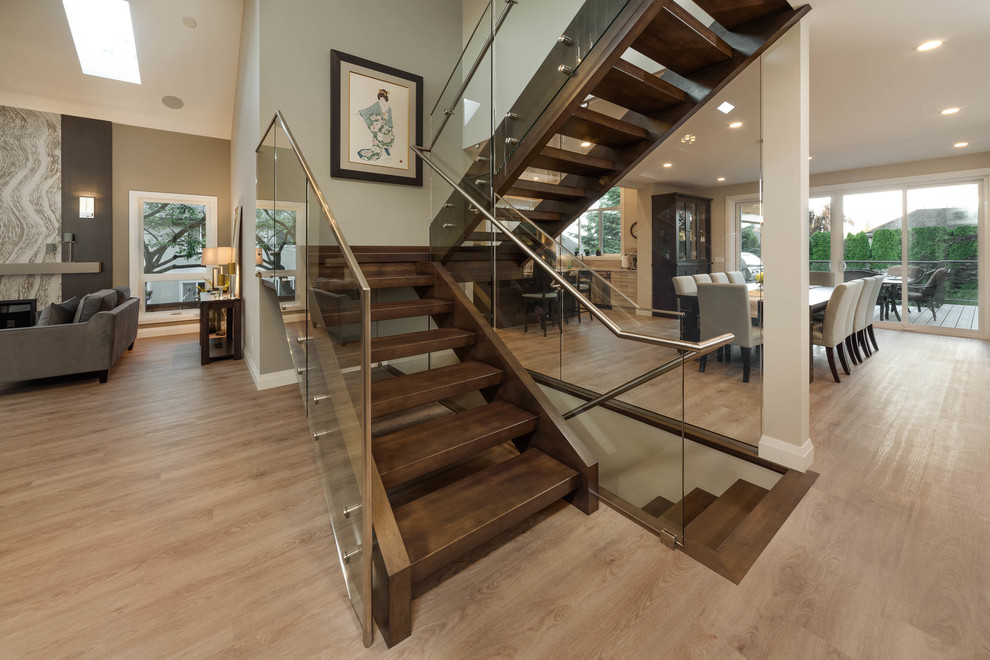 Imagen de escalera en U contemporánea de tamaño medio con escalones de madera, contrahuellas de madera y barandilla de vidrio