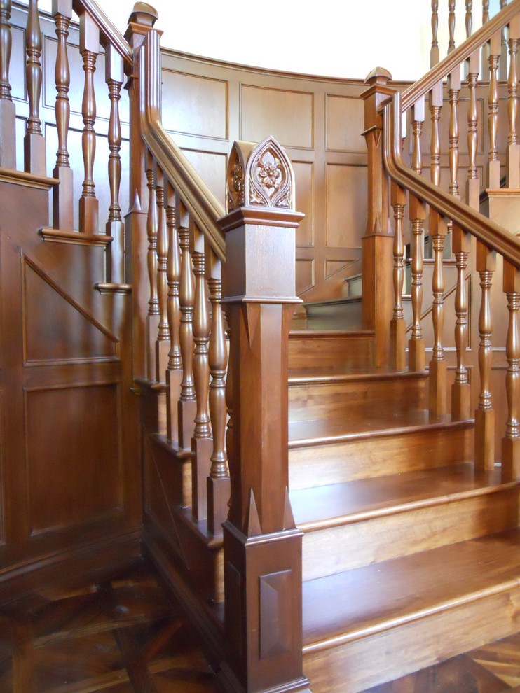 Пример оригинального дизайна: огромная изогнутая деревянная лестница в классическом стиле с деревянными ступенями