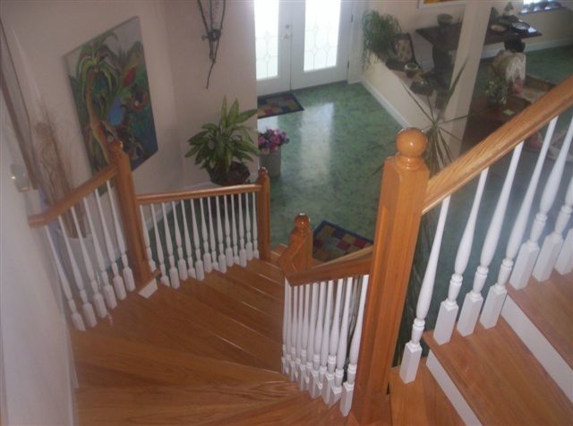 Свежая идея для дизайна: изогнутая лестница среднего размера в стиле кантри с деревянными ступенями и деревянными перилами - отличное фото интерьера