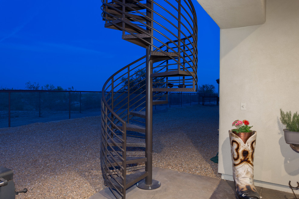 Foto di una scala a chiocciola stile rurale di medie dimensioni con pedata in metallo e alzata in metallo