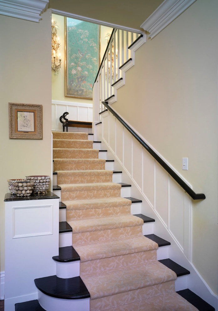 Imagen de escalera en U clásica de tamaño medio con escalones de madera y contrahuellas de madera pintada