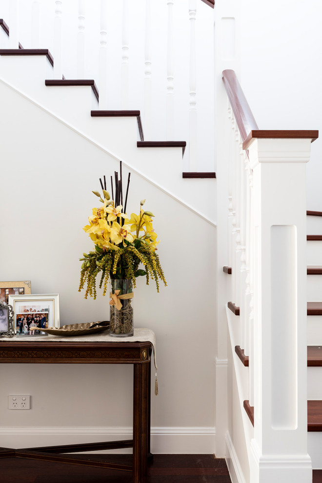 Photo of a medium sized traditional wood l-shaped wood railing staircase in Brisbane with painted wood risers.